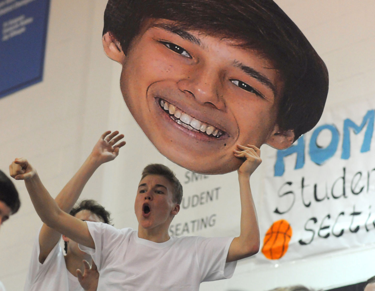 Junior Derek Steiert cheers and holds senior John Sears&#39; face cutout. Photo by Marisa - MHW_5547