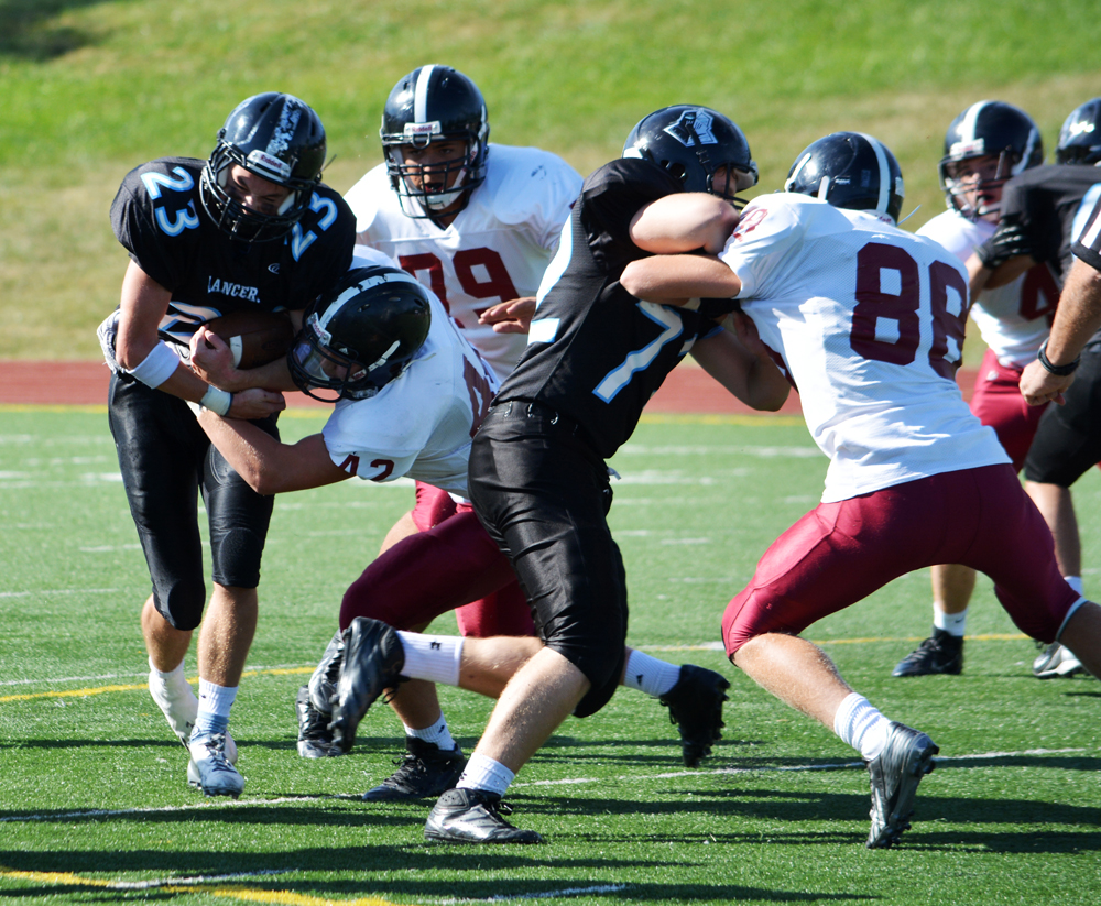 Running back Jackson Gossick powers through a tackle behind the line of ...