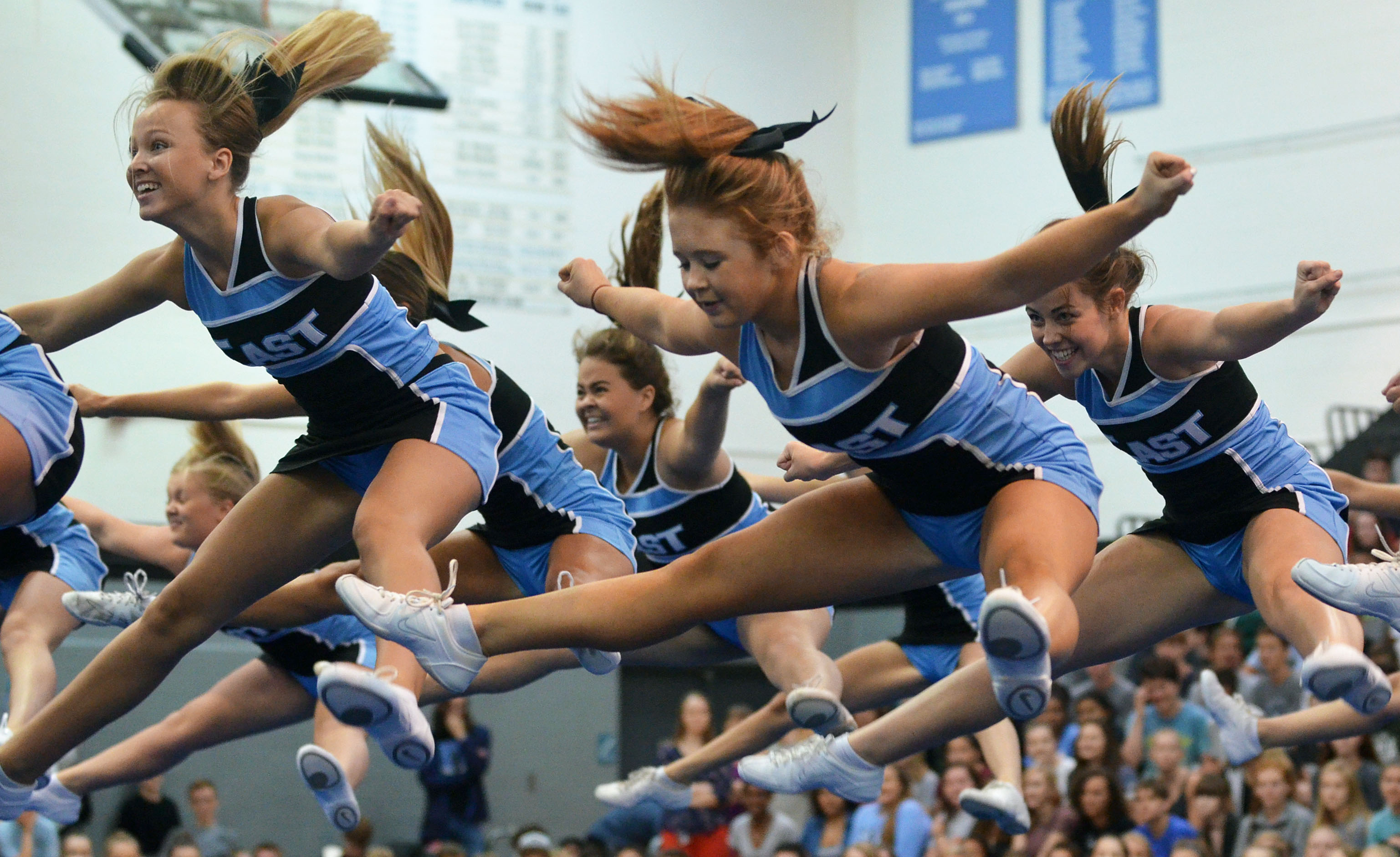 The varsity cheerleaders perform a routine with a series of jumps at ...