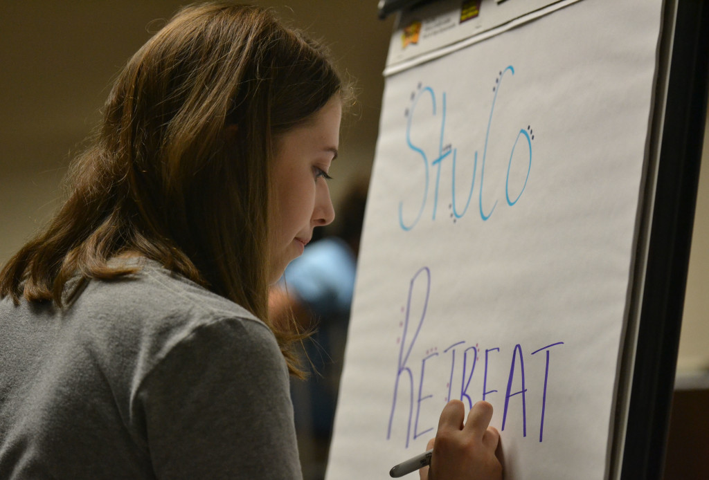Senior Morgan Biles writes on the sign to welcome all the student counsel that is yet to arrive. Photo by Morgan Plunkett