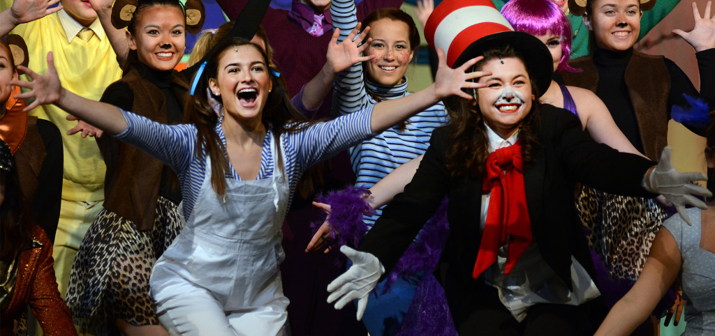 Sophomore Megan Walstrom, Junior Grace Chisholm, and the chorus pose at the end of the opening musical number. Photo by Ellen Swanson