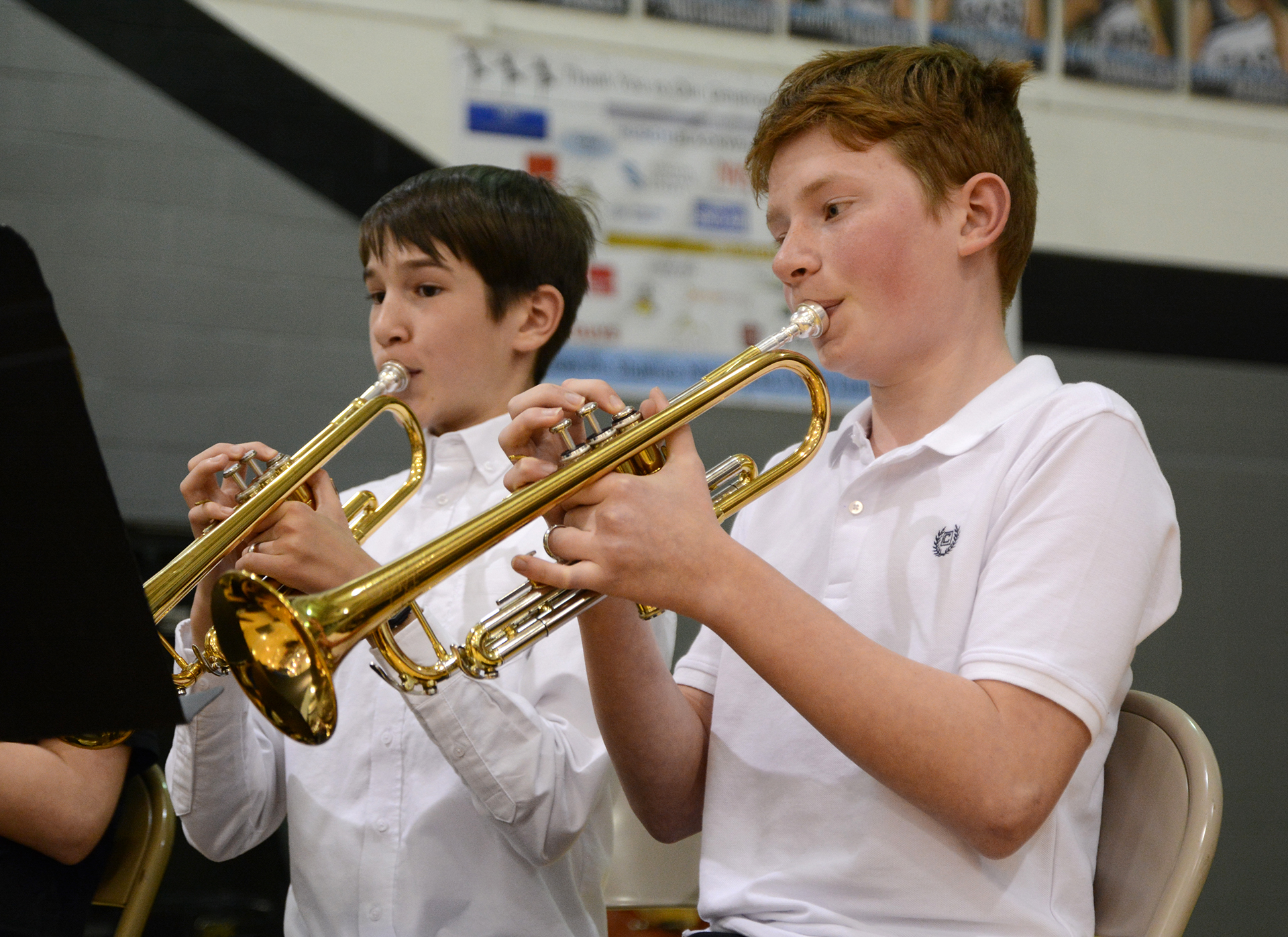 Two sixth grade elementary students play their trumpets during the ...