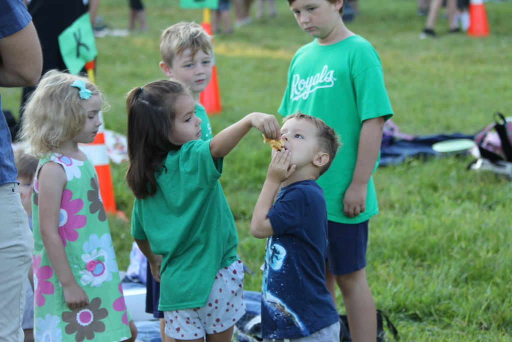 A Brookwood student shares a donut with friends on a laid out blanket. Photo by Ben Henschel. 
