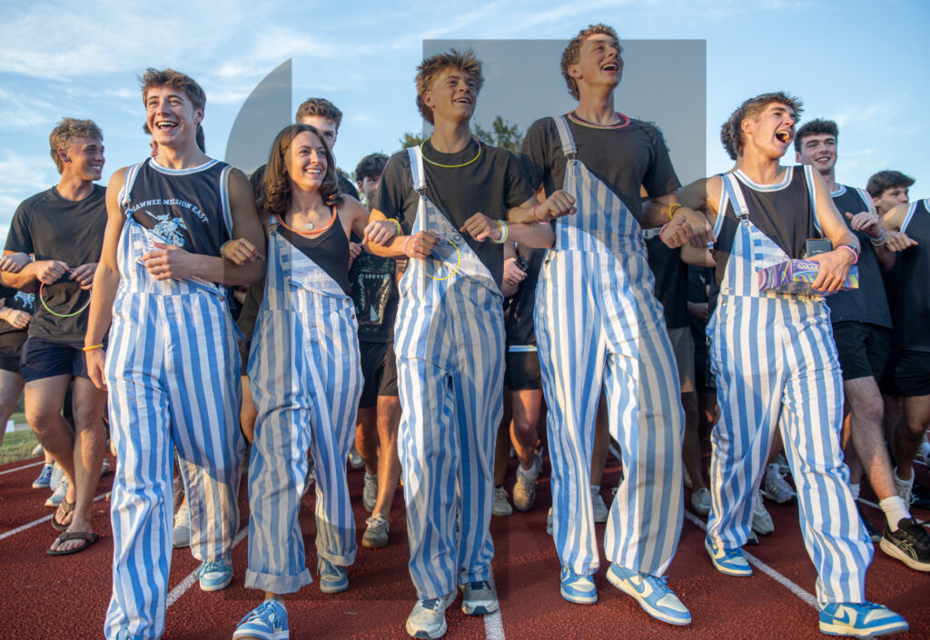 Senior Pep Executives walk in front of the student section as they lead students to their seats before the game starts. The theme was black-out and the SM East student store made jerseys for the game for students to purchase. Photo by Tyler Russell