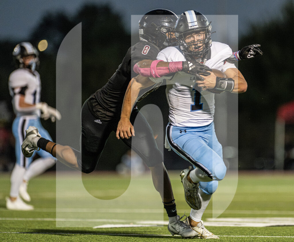 Senior Jack Reeves gets tackled on the sideline by a Lawrence linebacker in the second quarter. Photo by Will Griffith